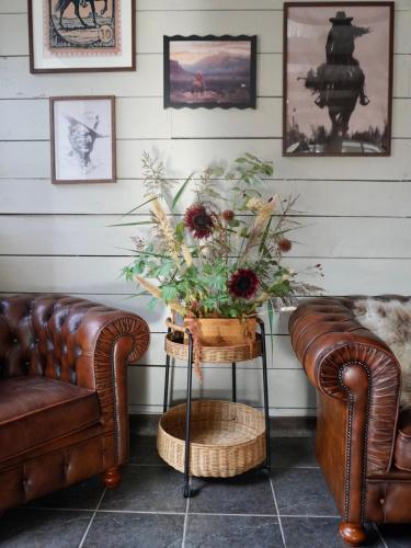 a room with two couches and a vase of flowers on a table at Long Valley Ranch & Lodge in Nykvarn