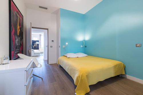 une chambre avec un lit et un mur bleu dans l'établissement Le Massena, à Nice