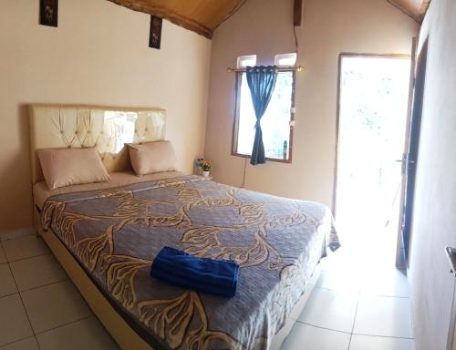 a bedroom with a bed with a blue bag on it at Senaru sunset house in Senaru