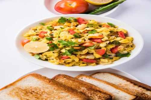 a bowl of rice salad with tomatoes and slices of bread at Hotel Moon Light Near Yashobhoomi Convention Centre in New Delhi