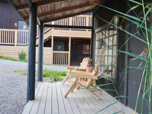 a wooden bench sitting on the porch of a house at Long Valley Ranch & Lodge in Nykvarn