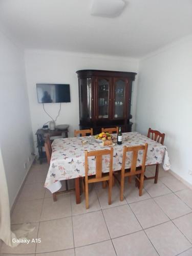 a dining room with a table and chairs and a television at Casa da Padaria in Caldas da Rainha
