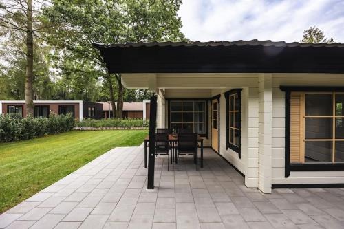 a pavilion with a table and chairs on a patio at Houten chalet 'De Blokhut' in Voorthuizen