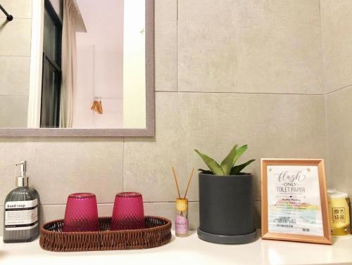 a bathroom counter with two baskets and a bottle of wine at SummerDay Seaview Studio Apartment at Kota Kinabalu City Centre in Kota Kinabalu