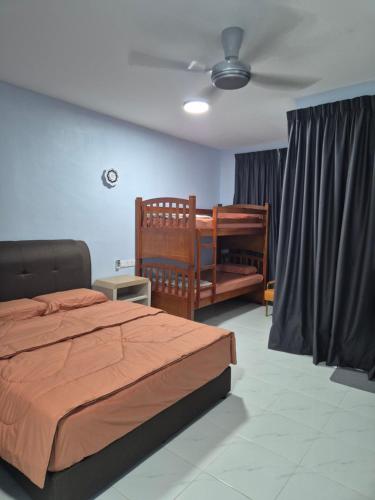 a bedroom with a bed and a crib and a ceiling at River Side Chalet Tioman in Kampung Genting