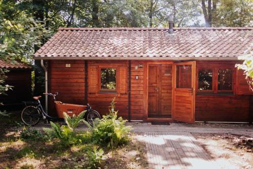 a small cabin with a bike parked in front of it at Sfeervol houten huisje met fijne buitenruimte op de Veluwe in Epe