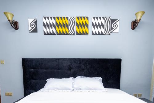 a bedroom with a bed with a black head board at Hotappa Suite Apartment in Kigali