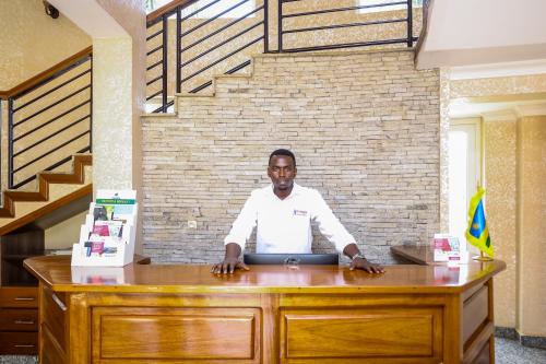 a man standing at a desk in an office at Hotappa Suite Apartment in Kigali