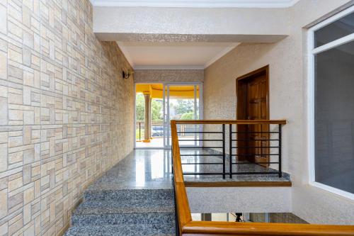 a hallway with a staircase and a brick wall at Hotappa Suite Apartment in Kigali