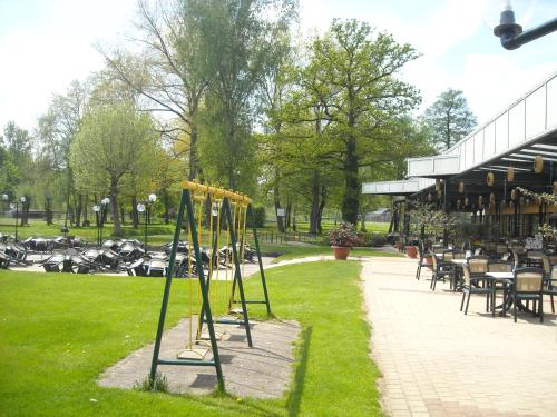 a group of poles in a park with tables and chairs at Hotel De Watermolen in Bocholt