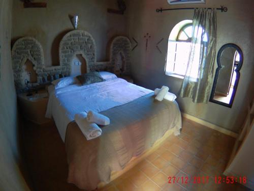 a bedroom with a large bed with towels on it at Riad Dar Poublanc in Merzouga