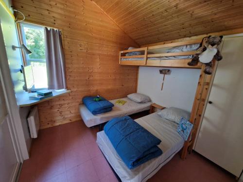 ein Zimmer mit zwei Etagenbetten und einem Fenster in der Unterkunft Camping Marmotel in Saint-Geniez-dʼOlt