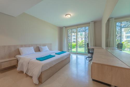 a bedroom with a bed with two blue towels on it at Elegant apartment with pool and beach access in Hurghada