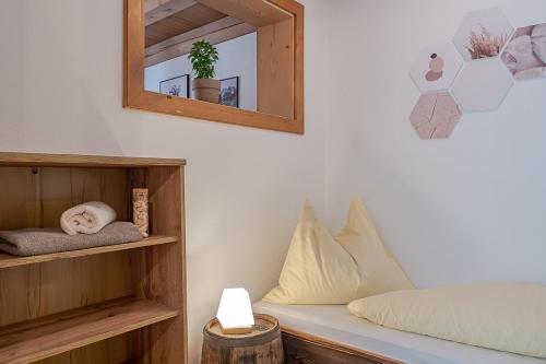 a bedroom with a bed with a mirror and a shelf at Payrgut in St. Wolfgang