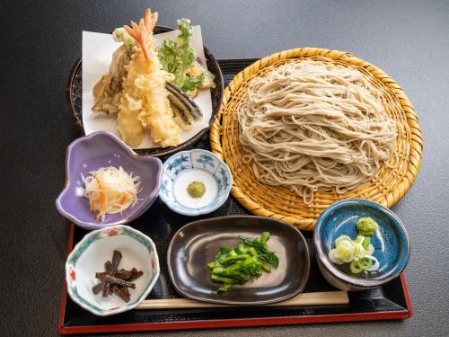 a tray of food with noodles and other dishes at 手打ちそばの宿 石田屋 in Togari
