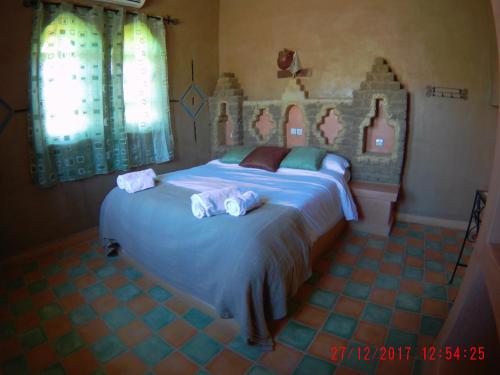 a bedroom with a large bed with towels on it at Riad Dar Poublanc in Merzouga