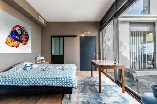 - une chambre avec un lit, une table et une porte dans l'établissement piscine chauffée vue mer villa standing, à Sète