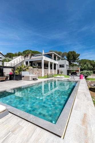 une grande piscine devant une maison dans l'établissement piscine chauffée vue mer villa standing, à Sète