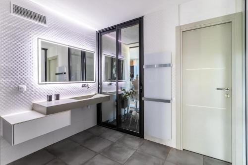 une salle de bain avec un lavabo et un miroir dans l'établissement piscine chauffée vue mer villa standing, à Sète