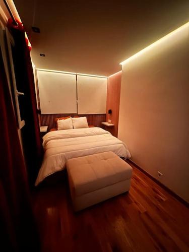 a bedroom with a bed and an ottoman in it at Appartement convivial pour séjourner in Le Kremlin-Bicêtre