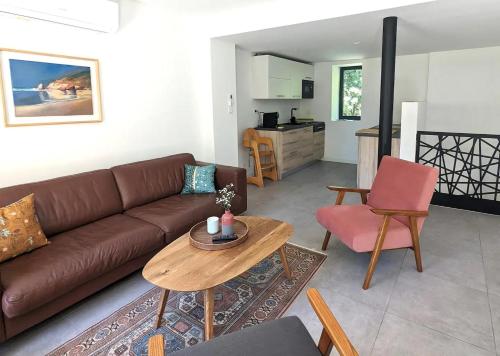 un salon avec un canapé marron et une table dans l'établissement Maison Neuve en Provence, à Lambesc