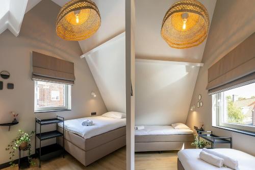 a room with two beds and two windows at Vakantiehuis DO57 centrum Domburg in Domburg