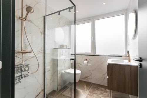 a bathroom with a shower and a toilet and a sink at Vakantiehuis DO57 centrum Domburg in Domburg