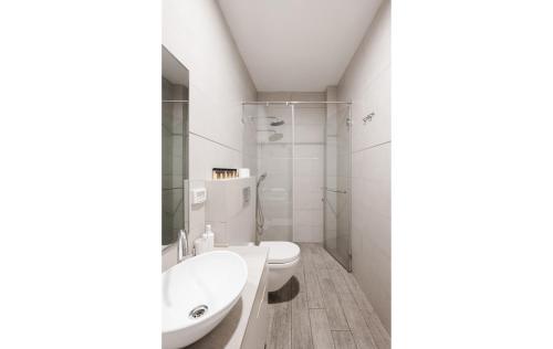 a white bathroom with a toilet and a sink at Adama by Sweett - Keren Hayesod Apartments in Jerusalem