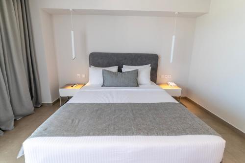 a bedroom with a large white bed with two night stands at Hotel Kriopigi in Kriopigi