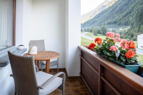 a balcony with a table and flowers on a window at Haus Limat in Schruns-Tschagguns