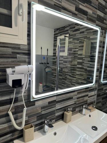 a bathroom with a sink with a large mirror at Charmante maison avec jacuzzi in Le Gosier