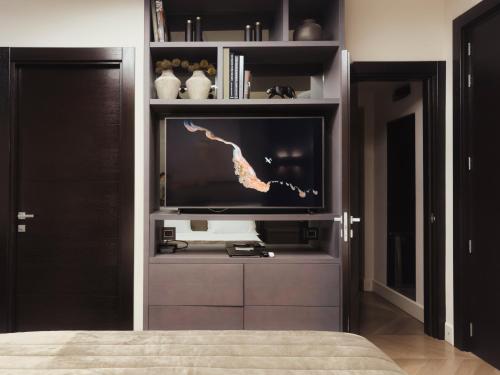 a bedroom with a flat screen tv in a entertainment center at Casa 300Mila in Lecce