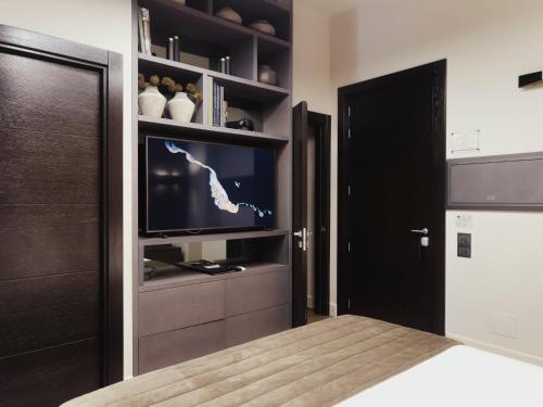 a bedroom with a bed and a flat screen tv at Casa 300Mila in Lecce