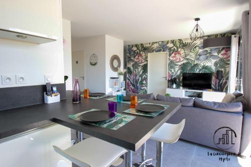 une cuisine et un salon avec une table et un canapé dans l'établissement Urban Jungle Appart Terrasse Clim Parking, à Albi