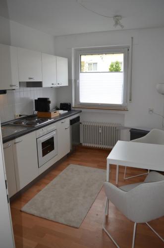 a kitchen with white cabinets and a table and a window at Auszeit in Langenfeld