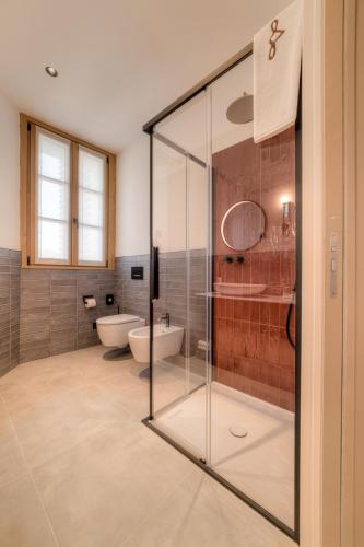 a bathroom with two sinks and a glass shower at Wine Hotel Ristorante San Carlo - Boutique Hotel & SPA in Chiuro