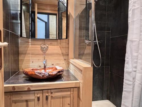 La salle de bains est pourvue d'une douche et d'un lavabo en bois. dans l'établissement Appartement rénové 2 pièces, accès direct aux pistes et proche centre station - FR-1-634-75, à Morzine