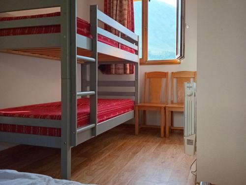 une chambre avec deux lits superposés et un bureau dans l'établissement Appartement confortable, 300m des pistes et commerces, balcon sud, parking, animaux acceptés - FR-1-618-14, à Albiez-Montrond