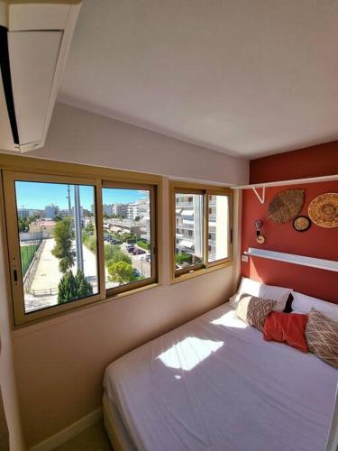 une chambre avec un lit et deux fenêtres dans l'établissement New top floor avec vue mer, Croisette à Palm Beach, à Cannes