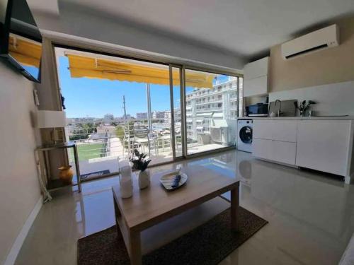un salon avec une table et une grande fenêtre dans l'établissement New top floor avec vue mer, Croisette à Palm Beach, à Cannes