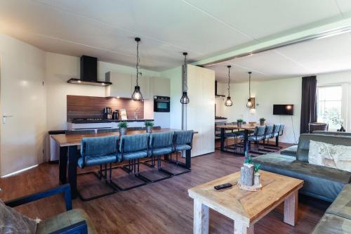 a living room with a couch and a table at Veluwe Vallei 16-person bungalow in Voorthuizen