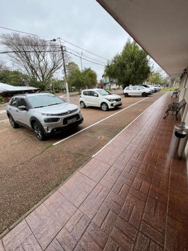 two cars parked on the side of a street at Hotel Mirador del Dayman in Termas del Daymán