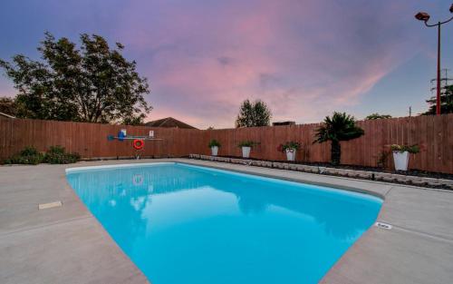 a swimming pool in a backyard with a wooden fence at Your Houston Vacation Getaway 3-BD Pool Patio in Pearland