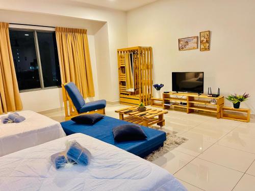 ein Wohnzimmer mit zwei Betten und einem Fernseher in der Unterkunft Near Sunway Damen Cozy Homestay in Subang Jaya