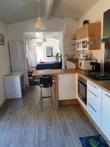 une cuisine avec une table et une chambre avec un lit dans l'établissement Studio avec jardin-Proche LDLC-Groupama Stadium-Eurexpo-métro, à Vaulx-en-Velin