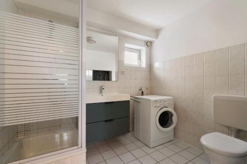 um banheiro com máquina de lavar e lavadora em Einfache Gästewohnung 'nordlicht' em Flensburg
