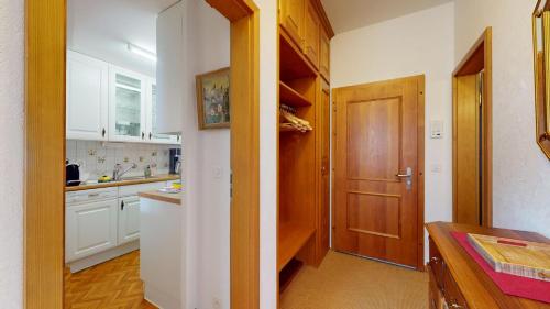 a kitchen with white cabinets and a wooden door at Abitaziun Bristol - Champfèr in Champfer