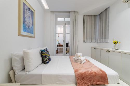 a white bedroom with a bed and a couch at 4 minutos da praia de Copacabana - NSC205 in Rio de Janeiro