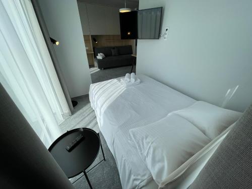 a bedroom with a white bed and a chair at Wilanów Residence Apartments in Warsaw