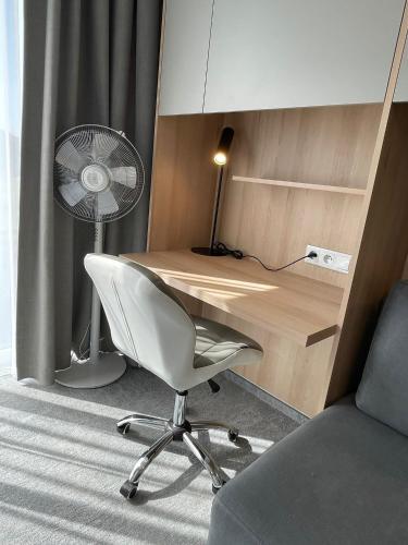 a room with a desk with a fan and a chair at Wilanów Residence Apartments in Warsaw